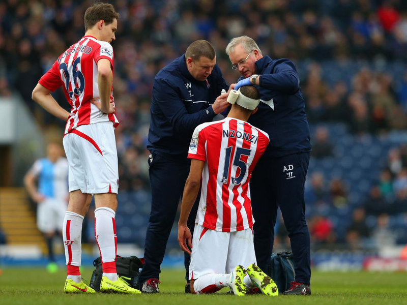 Поради голямата си височина, футболистът на УБА Стивън Нзонзи трябва да седи на колене, за да бъде превързана главата му