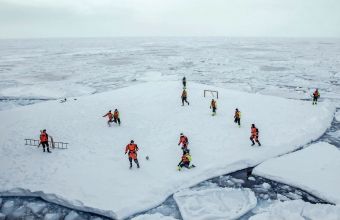 Футболен мач върху арктически леден блок край бреговете на Гренландия с участието на норвежки военнослужещи и работещи в института за морски изследвания в Берген. В близост до водата има и въоръжени ч