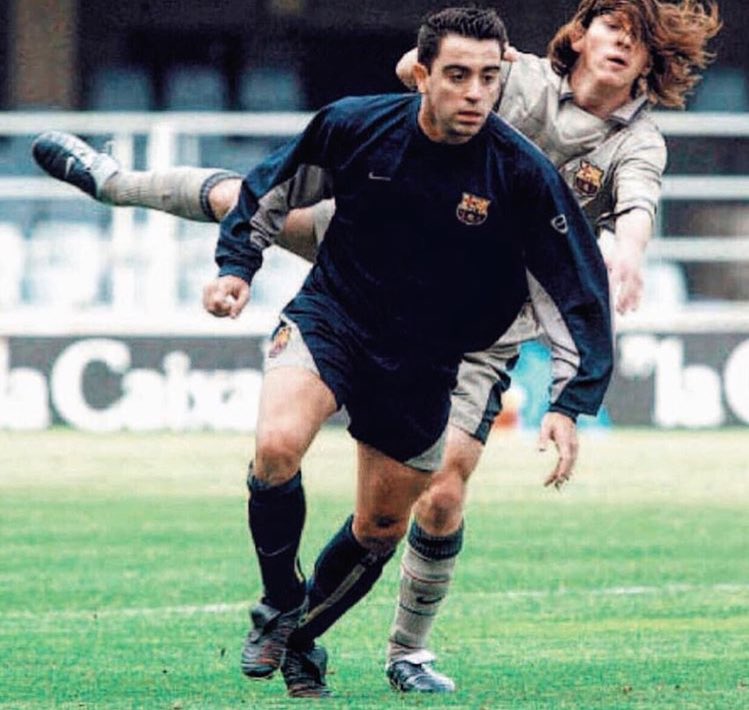 Шави отнема топката от Меси в мач между първия и втория отбор на Барса. 